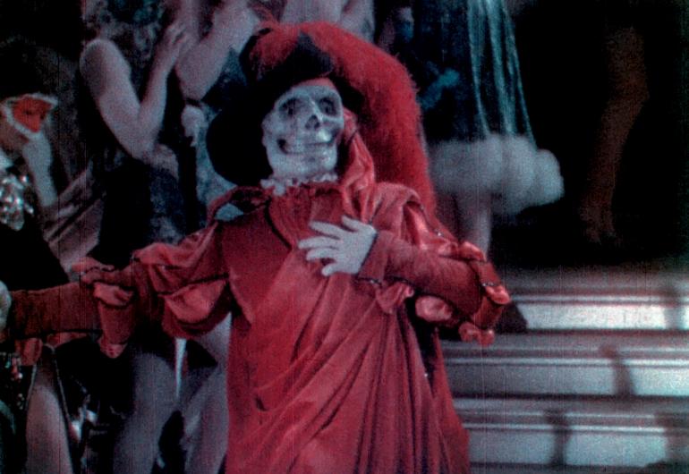 Still of Phantom of the Opera skeleton wearing a read draped robe and hat