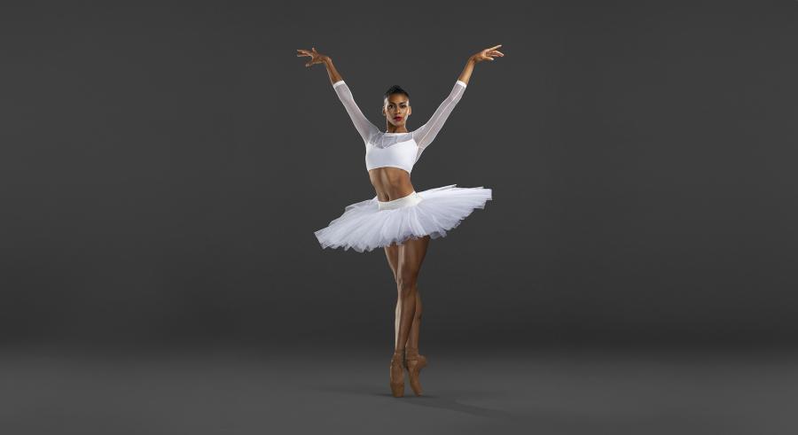 Female dancer in white tuto on pointe with arms up to each side.