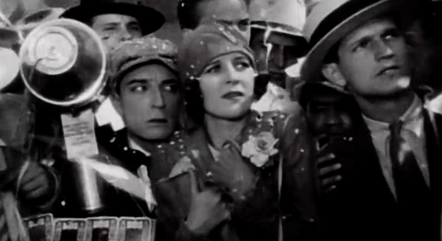 Buster Keaton and Marceline Day pressed together in a crowd, in a still from The Cameraman.