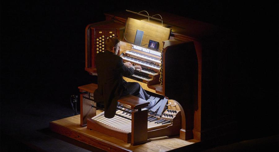 Aaron David Miller plays the organ under its lamp light.