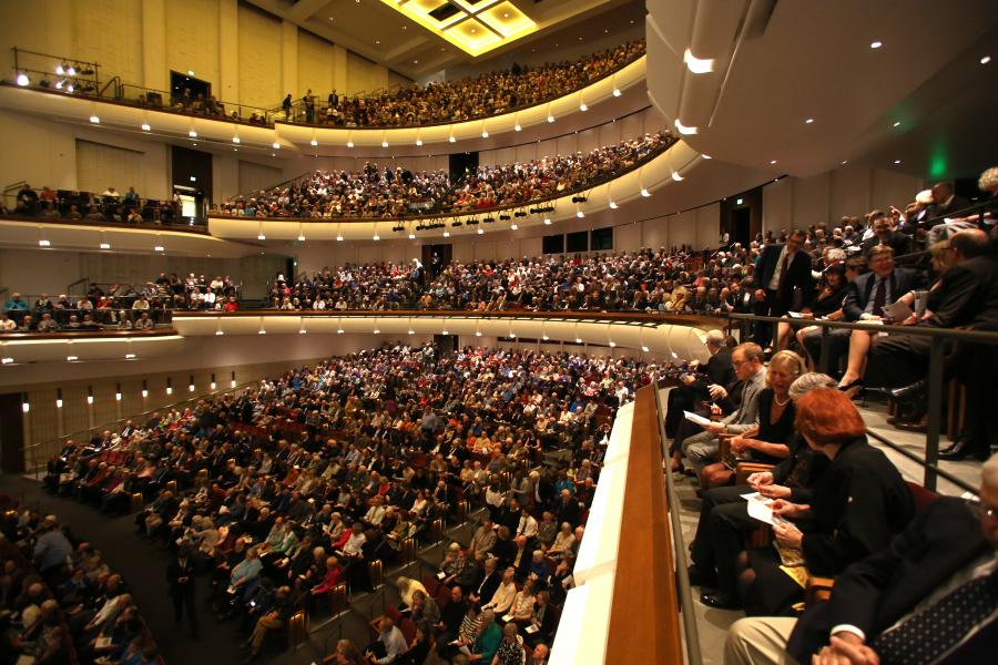 The seats and levels in the Northrop Auditorium taken from the middle level. The theatre is filled with audience members.