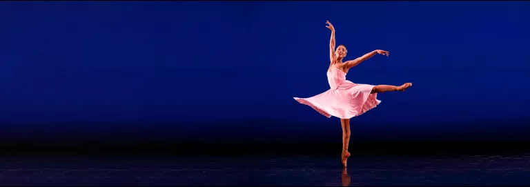 Amanda Smith dances on stage in a pink costume.