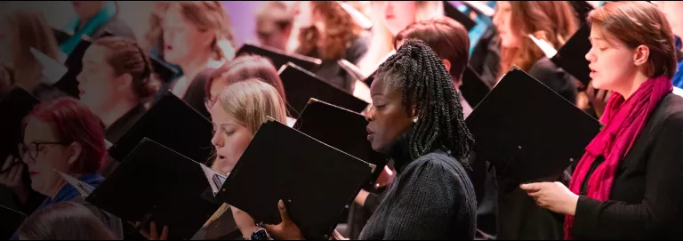 Side angle of choral members singing from books