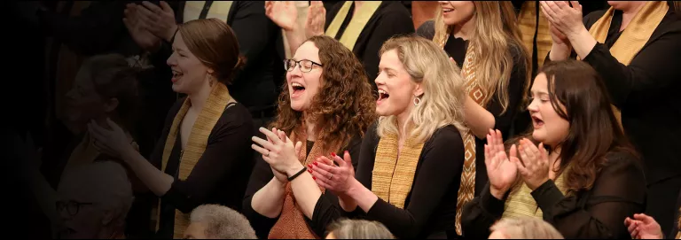 VocalEssence chorus claps and sings.