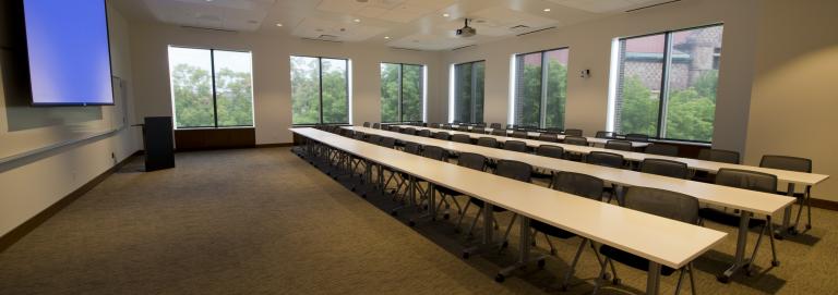 An large seminar room with long tables.