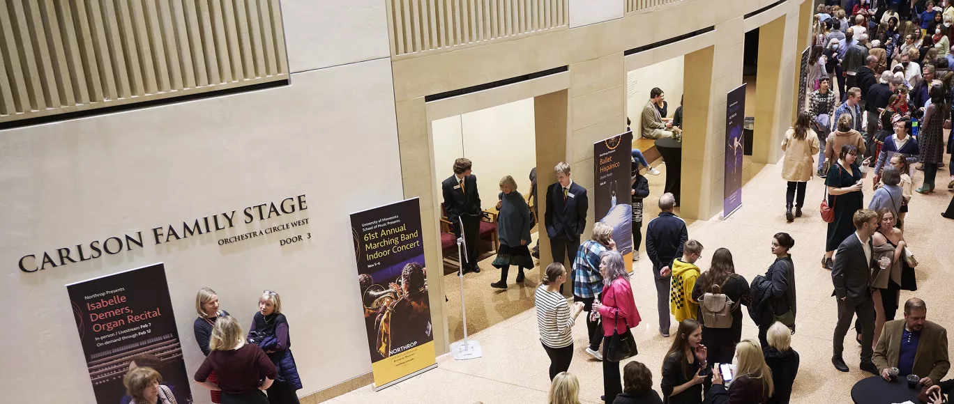 A crowd of people mingle in the Northrop lobby before a show.