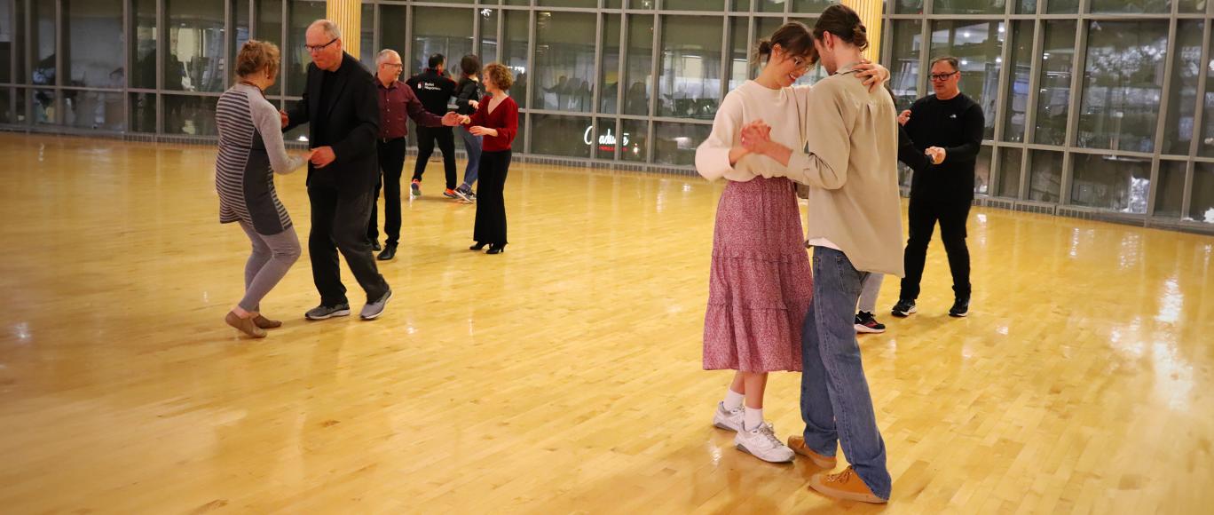 Participants take part in the Ballet Hispánico Latin Social Dance, spread out in couples along the floor, dancing together.