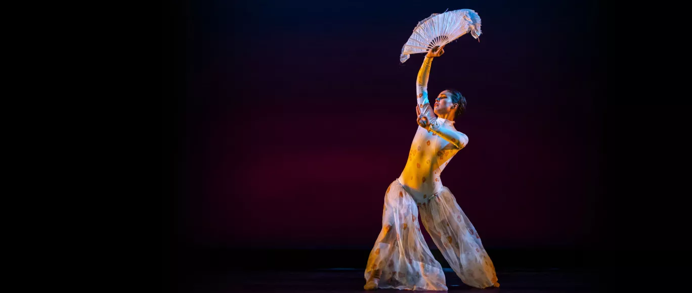 Oakland Ballet dancer Karina Eimon holds a fabric fan above her head. Image link to video.