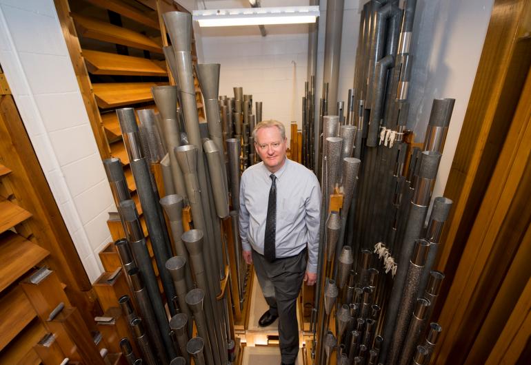 Dean Billmeyer surrounded by the pipes of the Northrop organ.