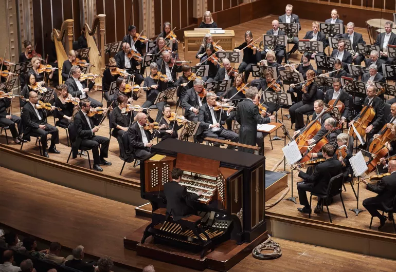 Aerial view of Paul playing the organ in front of a full orchestra