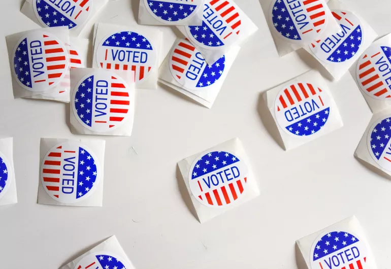 Scattered group of round American "I Voted" stickers on a table