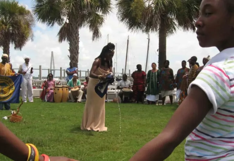 a group of people circle around a woman outside
