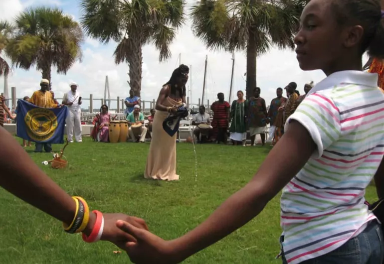 a group of people circle around a woman outside