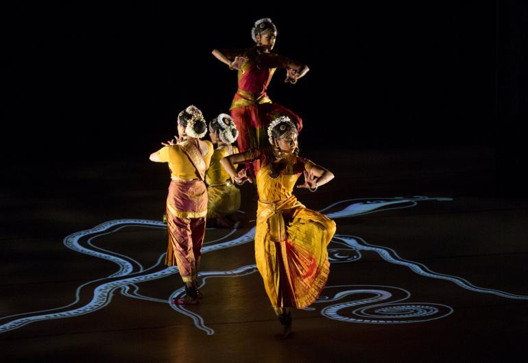 Dancers in formation with swirls of sand on the floor