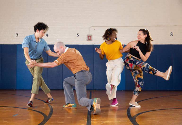 Swing Out dancers perform in a gymnasium setting.