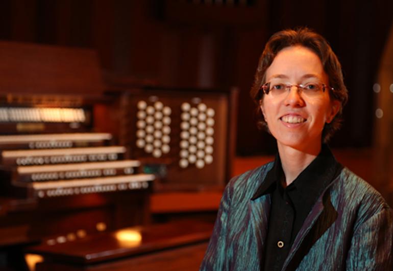 Isabelle Demers stands by an organ
