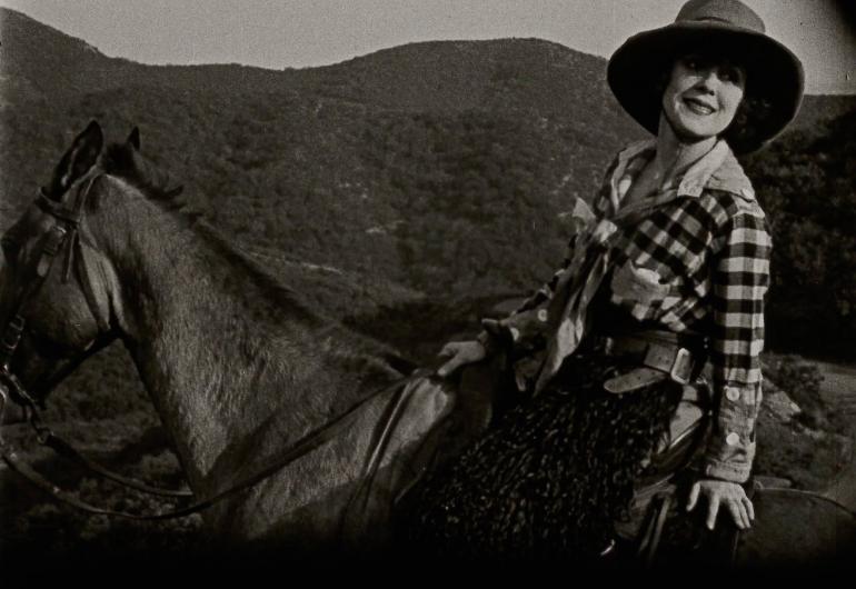 Rowdy Ann - One of Cinema's First Nasty Women - black and white still of a woman on a horse wearing a checked shirt and cowboy hat