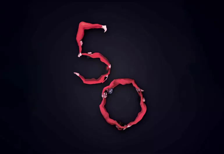Pilobolus bodies in red body suits make the shape of a five and a zero