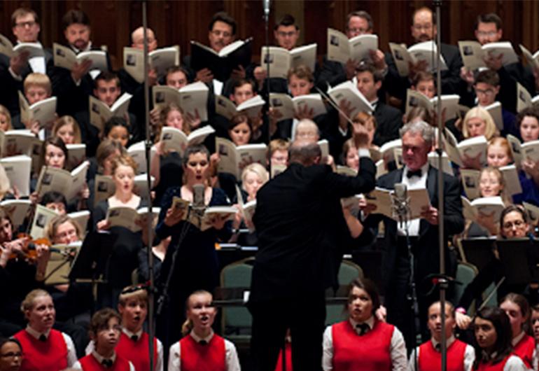 A conductor directs a large choir.