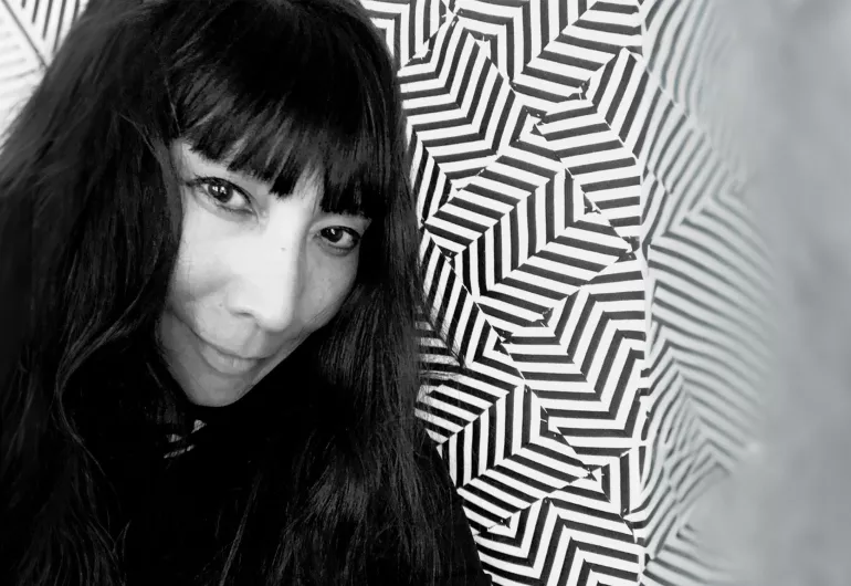 Brett Ishida with a black and white geometric pattern in the background