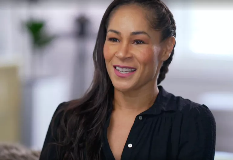 Ayodele Casel wearing a black top and smiling