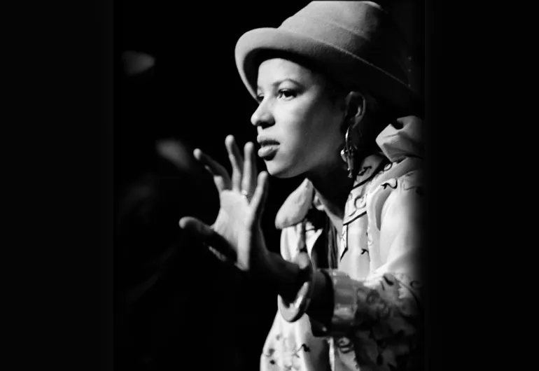 A black and white photograph of a woman wearing a hat.
