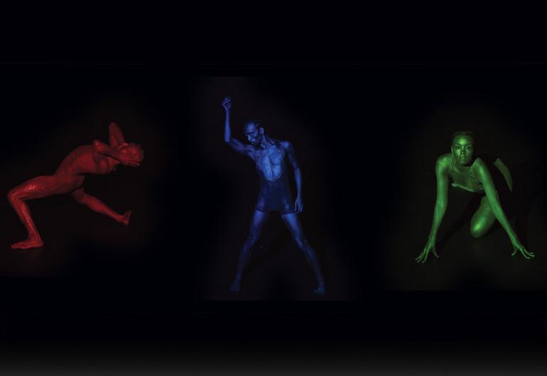 Three figures posing on a black background. They are colored red, blue, and green.