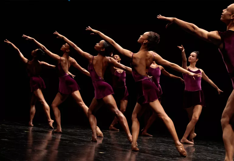 the company in purple, raising left arm in unison.