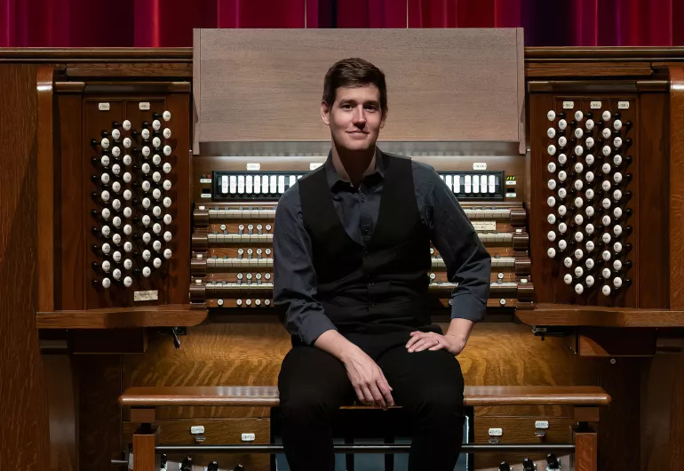 Greg Zelek sits at the Northrop organ facing the audience