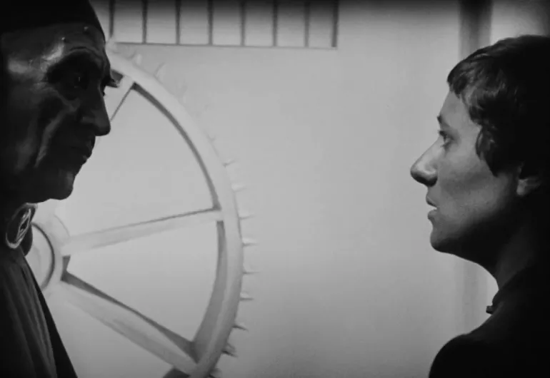 A shadowed man and woman stand opposite each other in the film “The Passion of Joan of Arc.”