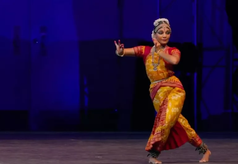 Video still of dancer in colorful costume