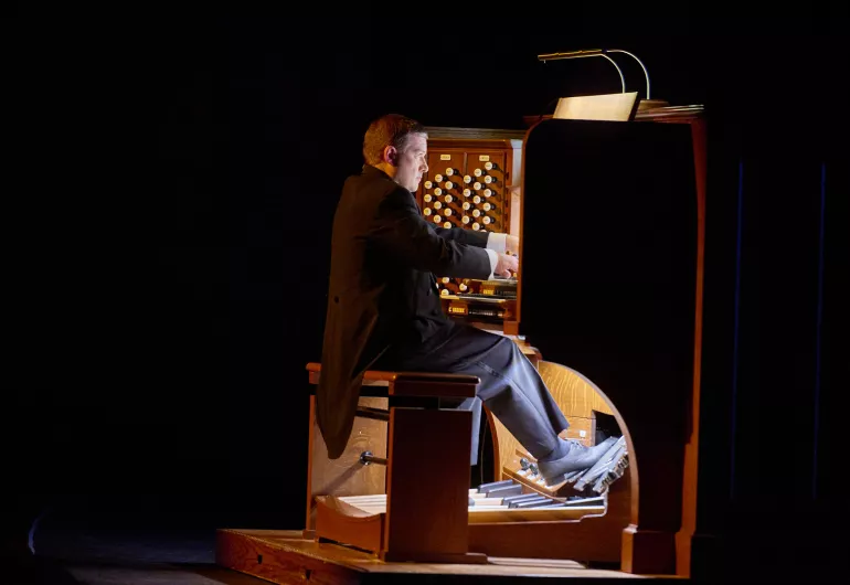 Aaron David Miller plays the organ under its lamp light.