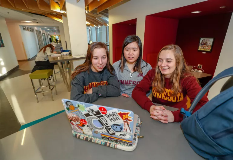 Students watching a laptop in a study lounge