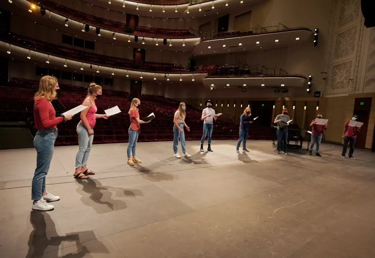 A line of students on the Northrop stage singing.