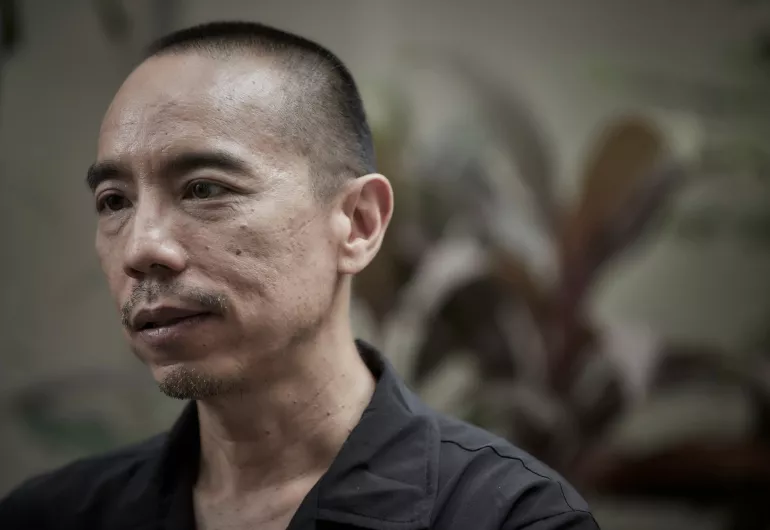 Apichatpong Weerasethakul wears a gray collared shirt.