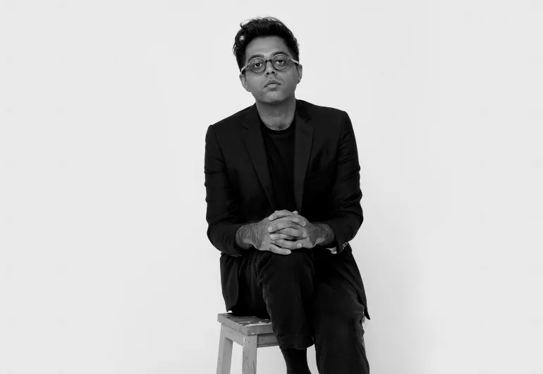 Rafiq Bhatia sits on a stool against a white backdrop.