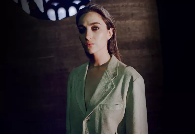 Kali Malone wearing a pale green jacket.