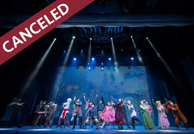 Chorus Performers on stage with Canceled banner on image