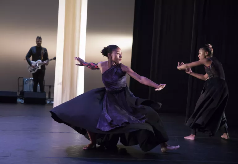 Two female dancers perform on stage.
