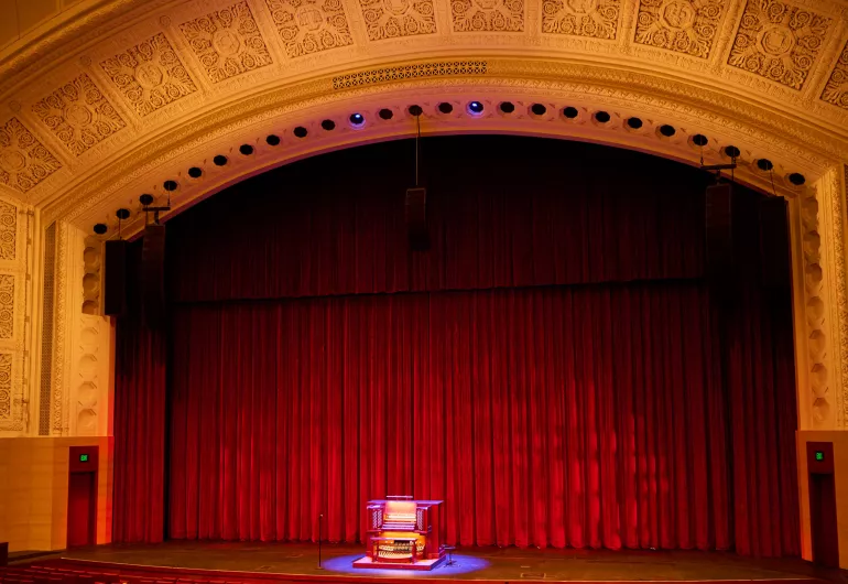 Northrop organ on stage. Medallions around the arch.