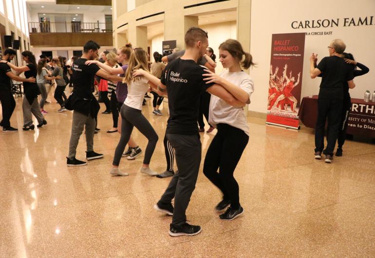 Multiple pairs of people dancing together in the Northrop Atrium.