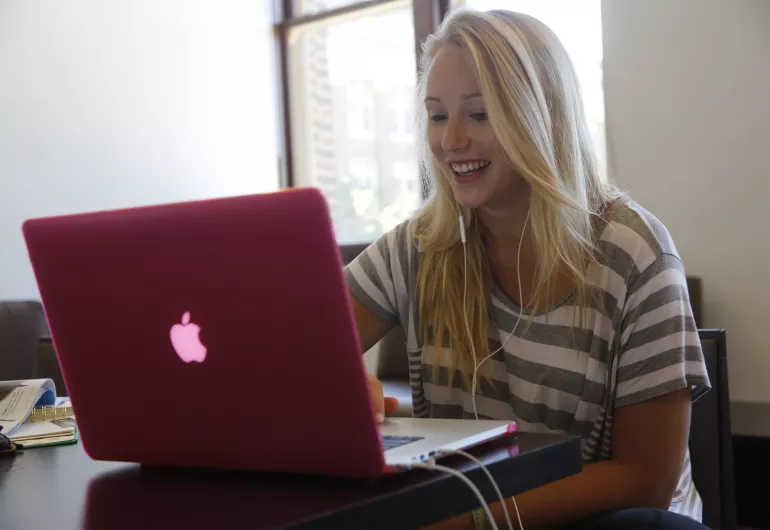 Student on laptop in study lounge.