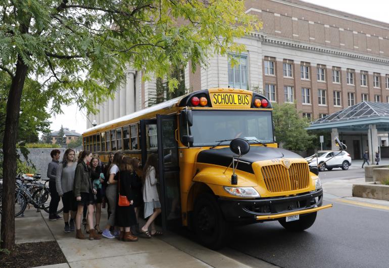 Students line up to board a school bus parked outside Northrop.
