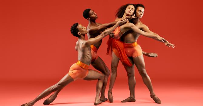 Four ballet dancers in orange on an orange stage