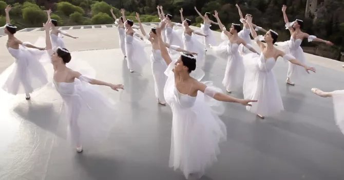 Ballerinas in white dancing on a rooftop