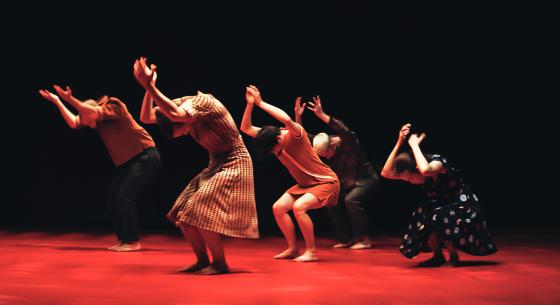 A group of woman dancing in a dramatic way as if they are struggling