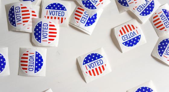 Scattered group of round American "I Voted" stickers on a table