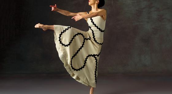Martha Graham dancer in a dress with black ribbon design on a white.