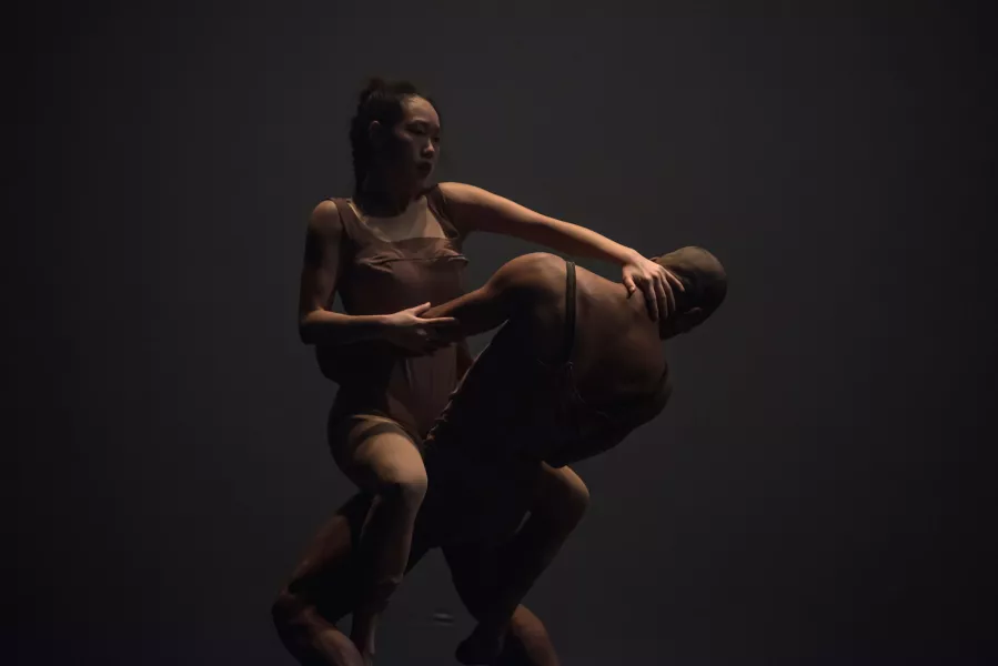 Dancers legs intertwined, she has her hand on his neck as he holds her waist