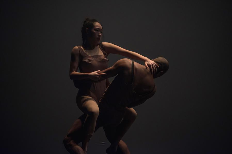 Dancers legs intertwined, she has her hand on his neck as he holds her waist